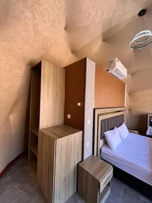 a small bedroom with a bed and a small closet at Wadi Rum Star Sky in Wadi Rum
