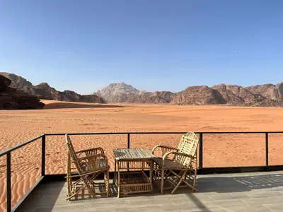 a patio with chairs and a table in the desert at Wadi Rum Star Sky in Wadi Rum