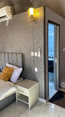 a bedroom with a bed and a bench next to a door at Fortuna Rum Bubble Hotel & Jeep Tours in Wadi Rum