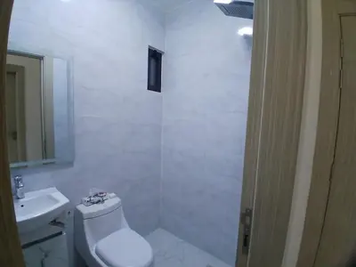 a white bathroom with a toilet and a sink at شقق السعادة 2 in Amman