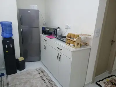 a kitchen with white cabinets and a refrigerator at شقق السعادة 2 in Amman