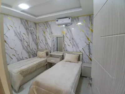 a small room with two beds and a marble wall at شقق السعادة 2 in Amman