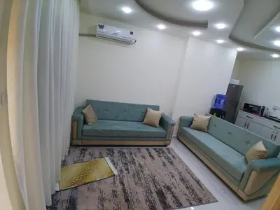 a living room with two blue couches and a rug at شقق السعادة 2 in Amman