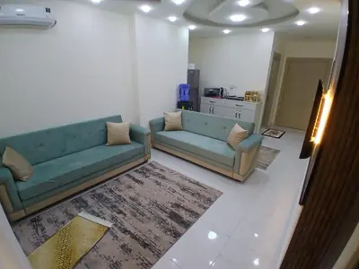 a living room with a blue couch and a rug at شقق السعادة 2 in Amman