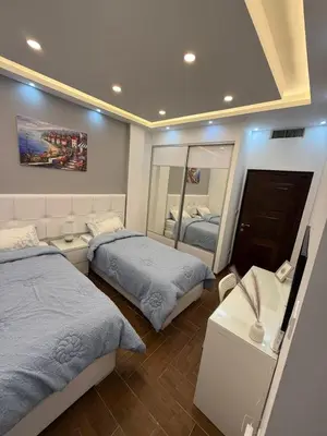 a bedroom with two beds and a mirror at شقة مميزة في عبدون -Special apartment in Abdon in Amman