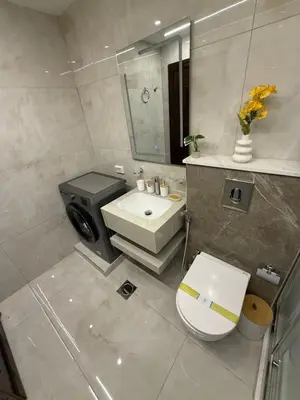 a bathroom with a white toilet and a sink at شقة مميزة في عبدون -Special apartment in Abdon in Amman