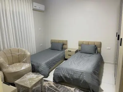 a room with two beds and a chair in it at jordanien madaba in Madaba