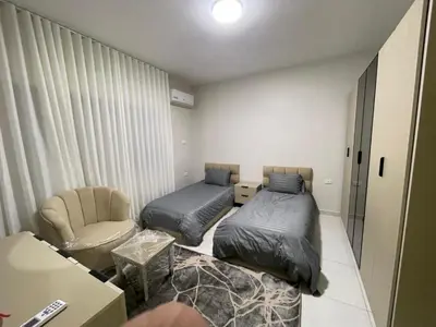 a small room with two beds and a chair at jordanien madaba in Madaba