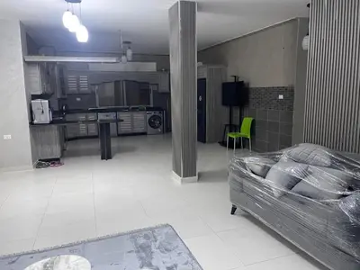 a living room with a bed and a kitchen at apartement khaled in Madaba