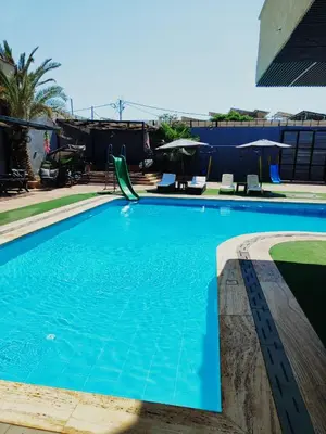 a swimming pool with blue water in a building at The Amazing View chalet in Al Rama