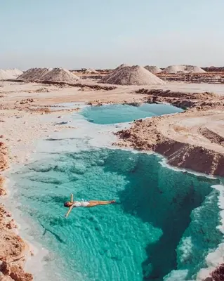 a man swimming in a pool of water in the desert at The Amazing View chalet in Al Rama