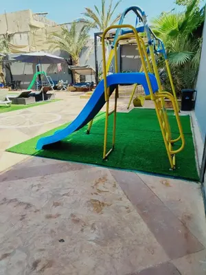 a playground with a blue and yellow slide at The Amazing View chalet in Al Rama