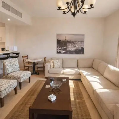 a living room with a couch and a table at Abdoun Elite Residence Stunning View in Amman