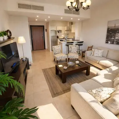 a living room with a couch and a table at Abdoun Elite Residence Stunning View in Amman