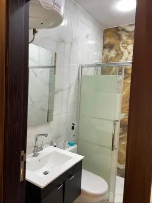 a bathroom with a sink and a toilet and a shower at Cozy Wabida in Amman