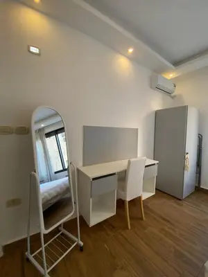 a room with a desk and chairs and a mirror at Cozy Wabida in Amman