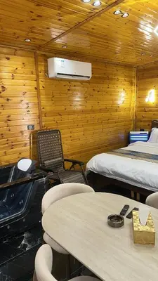 a room with two beds and two tables and chairs at Akwakh Al-Kanz Huts Ajloun Jor in Ajloun