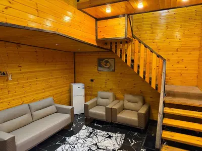 a living room with two couches and a staircase at Akwakh Al-Kanz Huts Ajloun Jor in Ajloun