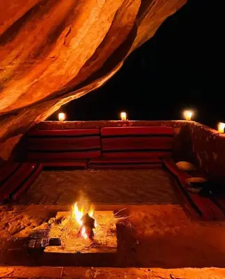 a fire pit with candles on top of it at night at Wadi Rum, Mars Cave in Wadi Rum