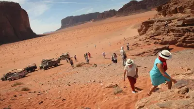 a group of people walking through the desert at Skylight Wadi Rum Camp in Disah