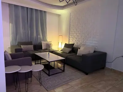 a living room with a couch and two tables at 3 bedroom cozy apartment prime location in Irbid in Irbid