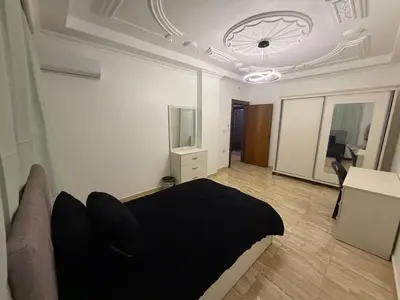 a bedroom with a black bed and a television at 3 bedroom cozy apartment prime location in Irbid in Irbid