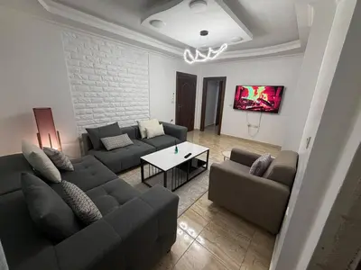 a living room with two couches and a table at 3 bedroom cozy apartment prime location in Irbid in Irbid
