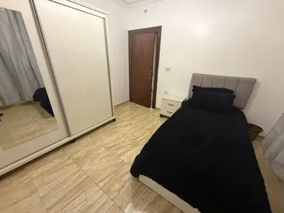 a bedroom with a bed and a large mirror at 3 bedroom cozy apartment prime location in Irbid in Irbid