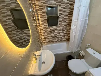 a bathroom with a sink and a toilet and a mirror at 3 bedroom cozy apartment prime location in Irbid in Irbid