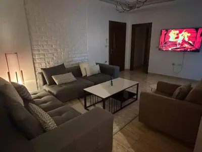 a living room with a couch and a table at 3 bedroom cozy apartment prime location in Irbid in Irbid