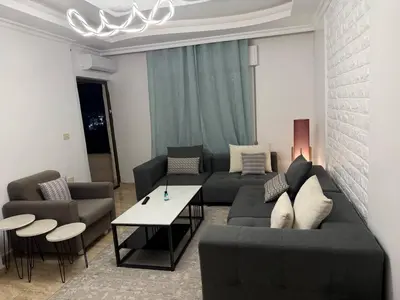 a living room with a couch and a table at 3 bedroom cozy apartment prime location in Irbid in Irbid