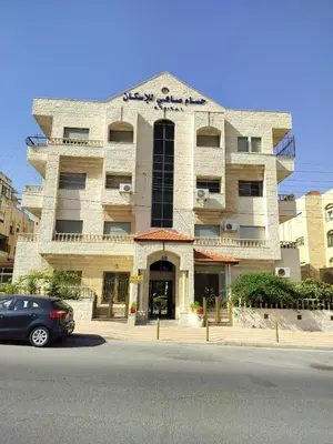a building with a car parked in front of it at Cozy 3 bed-2 bath furnished apartment in Amman