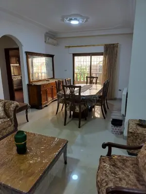 a living room with a table and chairs at Cozy 3 bed-2 bath furnished apartment in Amman