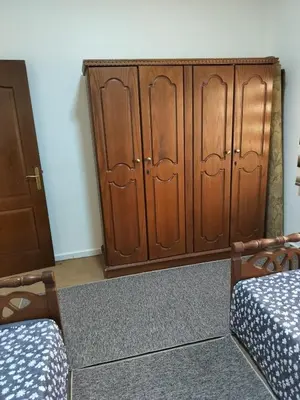 a room with two wooden cabinets and a bed at Cozy 3 bed-2 bath furnished apartment in Amman