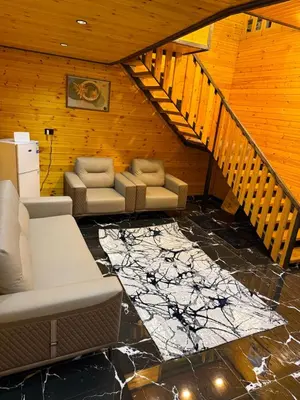 a living room with couches and a staircase at Akwakh Al-Kanz اكواخ الكنز عجلون in Ajloun