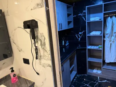 a shower in a bathroom with a phone on the wall at Akwakh Al-Kanz اكواخ الكنز عجلون in Ajloun