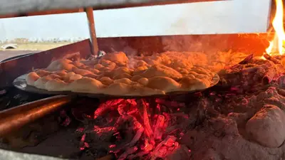 a pizza is being cooked on a grill at Your Bedouin family home in Disah