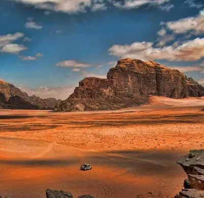 a car parked in the desert near a mountain at Your Bedouin family home in Disah