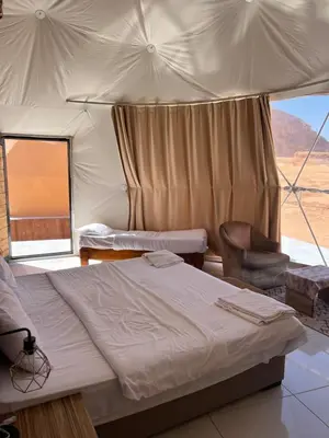 a bedroom with a bed and a chair in a tent at Infinity Dunes Camp in Disah