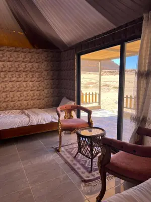a room with a bed and a chair and a table at Infinity Dunes Camp in Disah