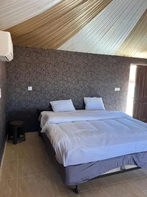 a bedroom with a large bed with a wooden ceiling at Infinity Dunes Camp in Disah