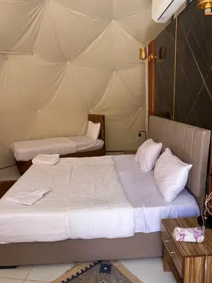 a bedroom with two beds in a tent at Infinity Dunes Camp in Disah