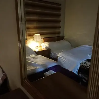 two beds in a room with a mirror at Petra Eyes in Wadi Musa