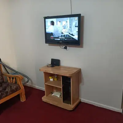 a flat screen tv on a wall with a wooden table at Petra Eyes in Wadi Musa