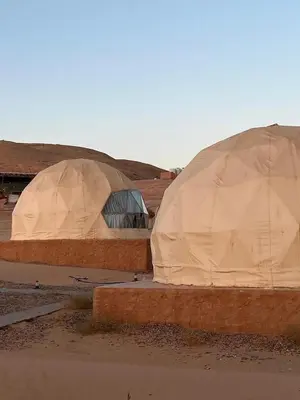 two domed tents are sitting in a field at Wadi rum camp in Wadi Rum