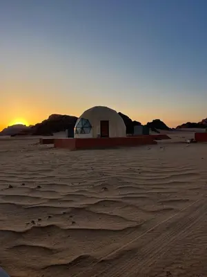 a dome in the desert with the sunset in the background at Wadi rum camp in Wadi Rum
