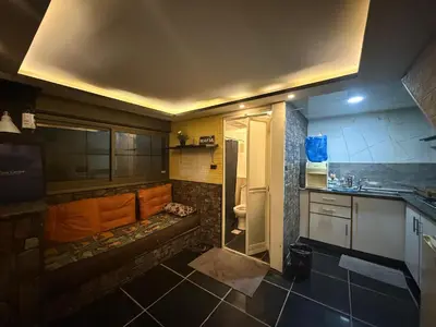 a small kitchen with a sink and a refrigerator at City huts in Umm Uthainah