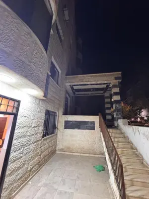 a brick building with a staircase in the night at شقه للإيجار قرب جامعة اليرموك in Irbid