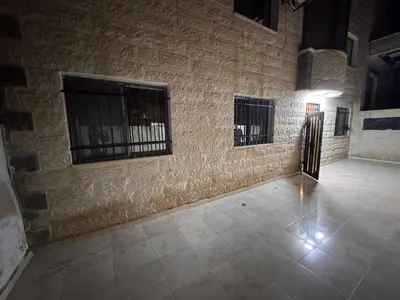 a room with two windows and a brick wall at شقه للإيجار قرب جامعة اليرموك in Irbid