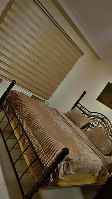 a bed in a room with a window with a blind at شقه مفروشه بالكامل متوفر فيها جميع الخدمات in Amman